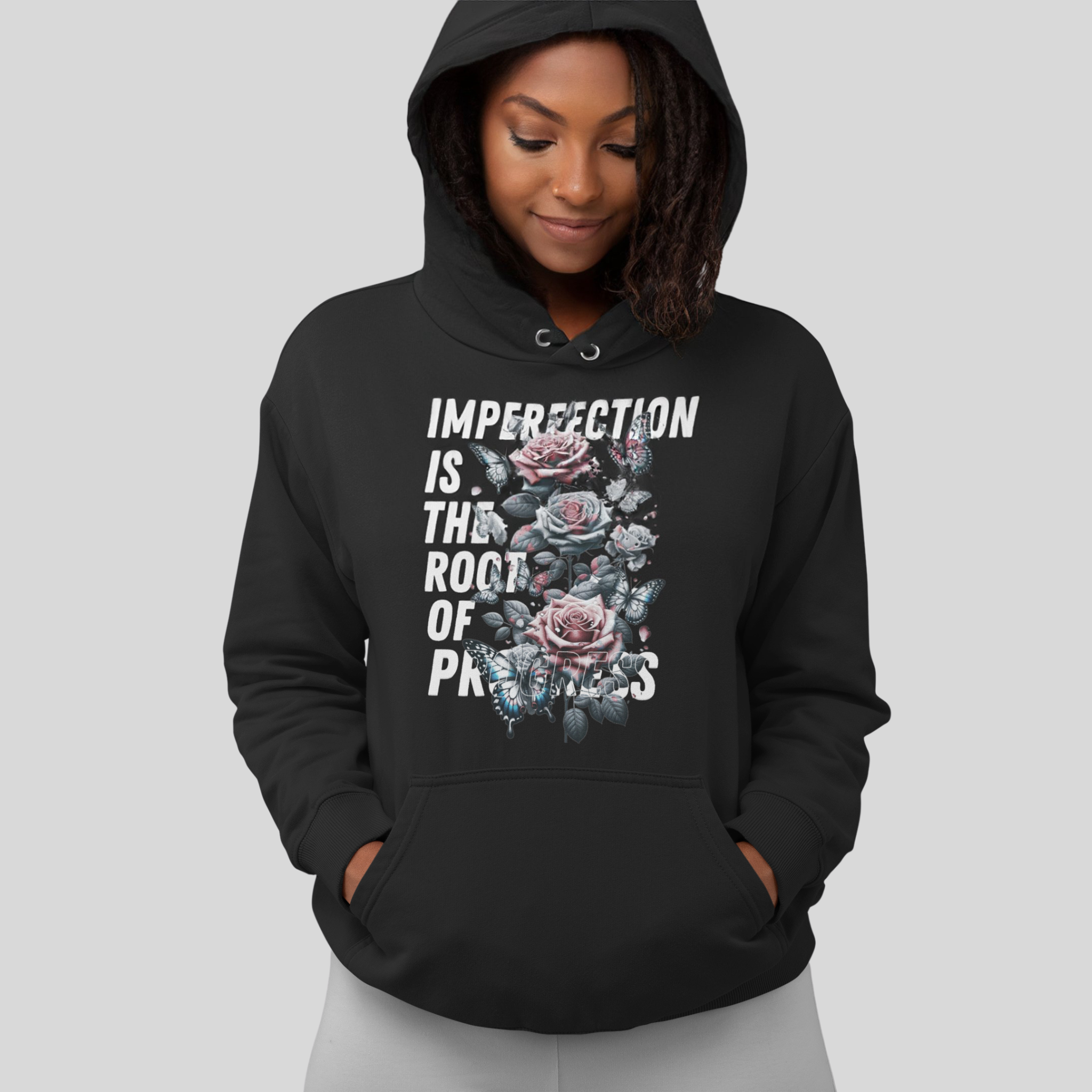 Image of a black hoodie with the inspiring message 'Imperfection is the root of growth' printed in white on the front. Accompanying the text is a beautifully detailed floral graphic, adding a touch of elegance and nature to the design. The hoodie is made from a comfortable blend of 80% cotton and 20% polyester, ensuring both durability and softness. This design elegantly combines a powerful message with artistic flair, making it both meaningful and stylish. black imperfectly qualified hoodie.